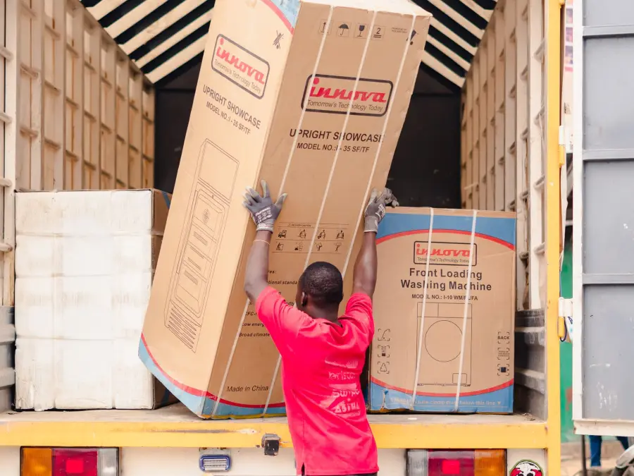 A worker loading boxed items onto a truck