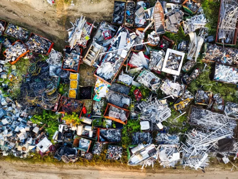 An aerial view of sorted metal piles at a scrap yard