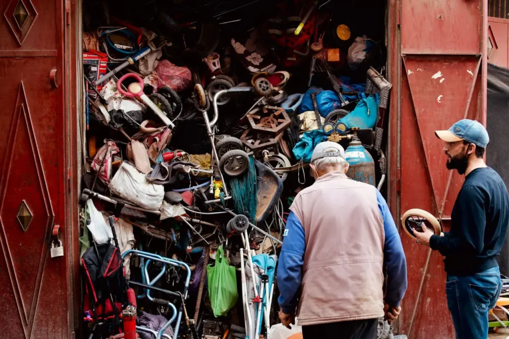People sorting through a storage space packed with household items